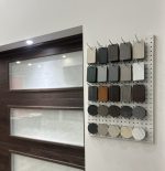 A display board featuring a variety of textured color swatches for custom garage doors, ranging from wood grains to metallic finishes.