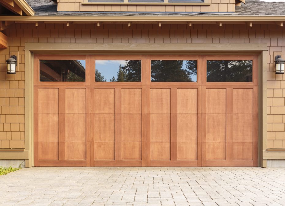 Contemporary natural wood grain garage door with rectangular glass window panels.