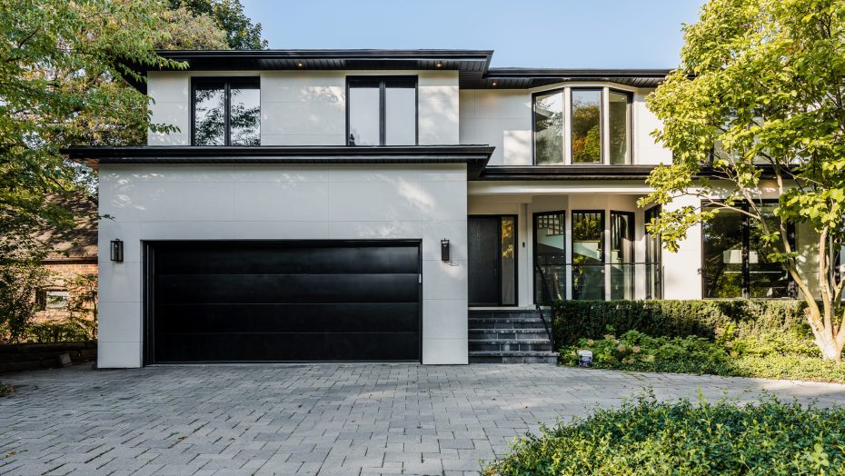 Minimalist black flush panel garage door on a contemporary luxury white stucco home.