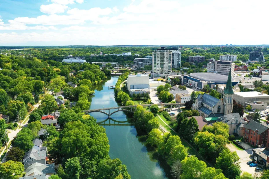 Aerial scenic view of the Speed River flowing through downtown Georgetown, Ontario, featuring local architecture and lush greenery.