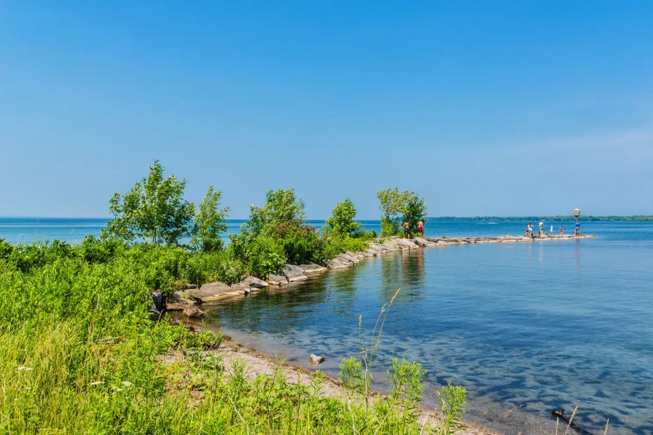 Blue water and green shoreline at the point of Couchiching Beach Park, a top Orillia waterfront destination.