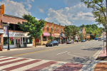 Street level view of Queen Street South in downtown Bolton, Ontario, featuring local shops like Caffe Contessa and Humber Valley Dental.