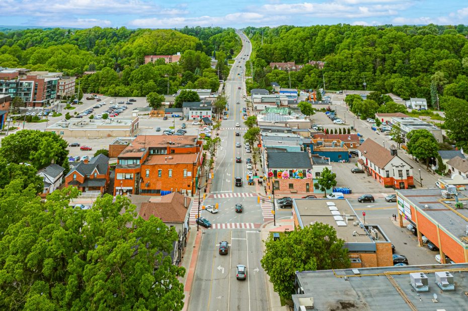 Aerial bird's-eye view of downtown Bolton Ontario showing Queen Street and surrounding green hills.