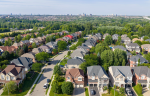 High-angle drone shot of a Bolton Ontario housing development featuring detached homes and lush green spaces.