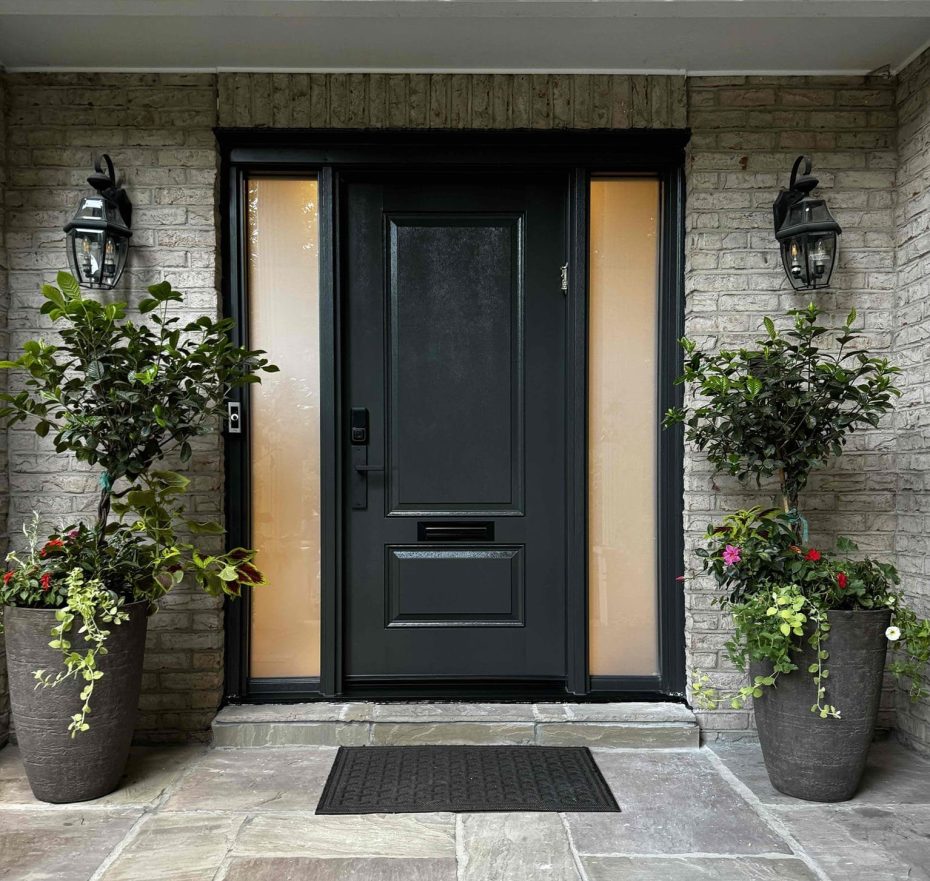 Charcoal gray fiberglass front door with frosted glass sidelights installed on a brick home entryway.