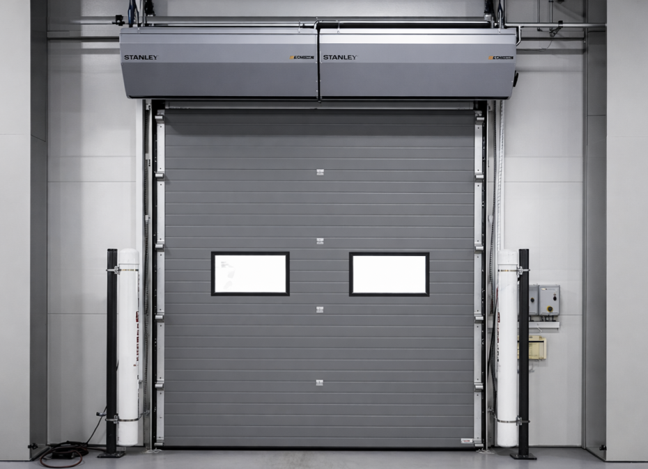Commercial sectional garage door featuring a high-performance overhead air curtain for energy savings.