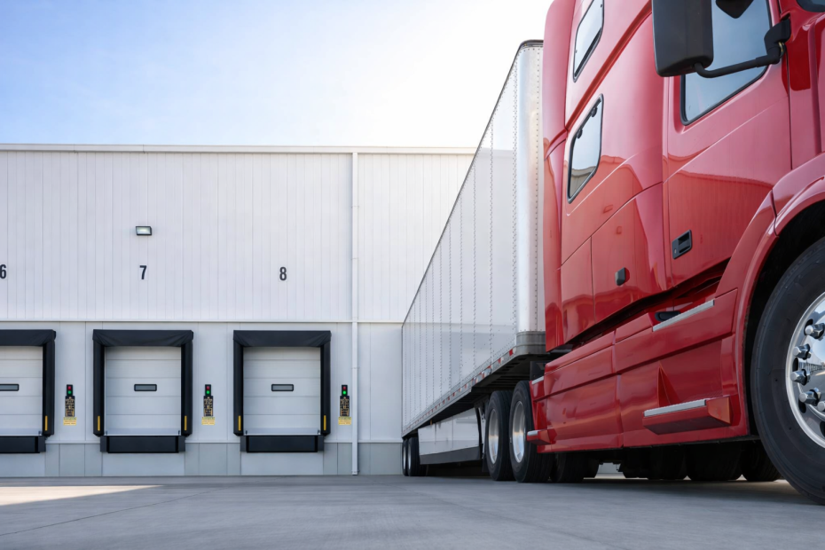 A set of heavy-duty black foam dock seals installed on a red commercial garage door at a warehouse to provide a weather-tight compression seal.