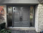 Contemporary grey double steel entry doors featuring decorative glass sidelights and smart lock security.
