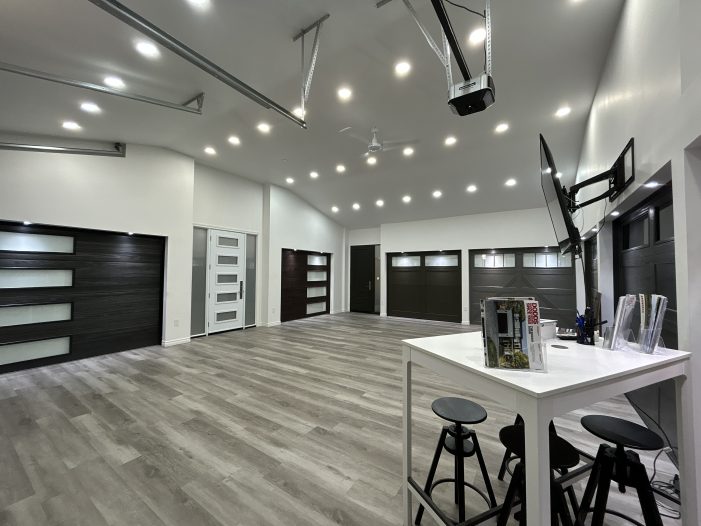 Interior of a Dodds Garage Doors showroom featuring modern glass and wood-finish garage door models.