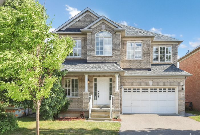 Modern white double car garage door installed on a detached brick home in Concord, Ontario.