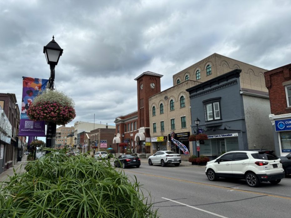 A busy street in downtown Aurora, Ontario, showing the local community served by professional garage door installers.