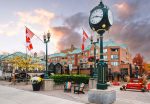 The iconic Town Square clock and Canadian flags in downtown Oakville, Ontario.