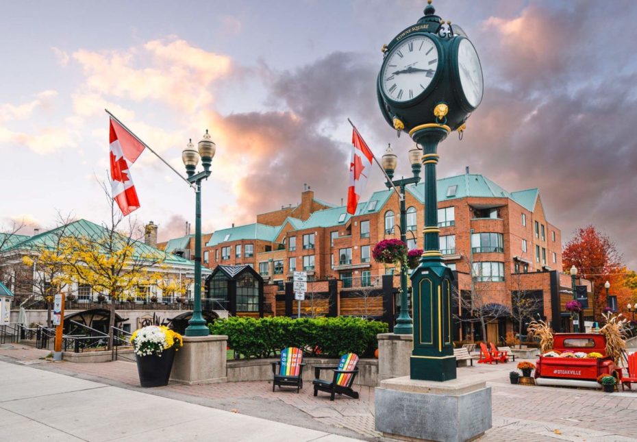 The iconic Town Square clock and Canadian flags in downtown Oakville, Ontario.