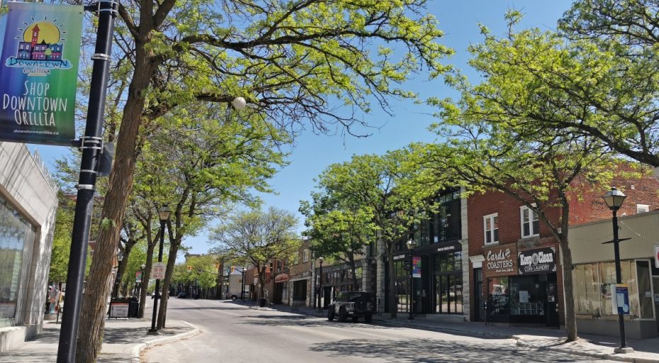 A sunny morning on in downtown Orillia, Ontario, showing local businesses and the Shop Downtown Orillia banner.