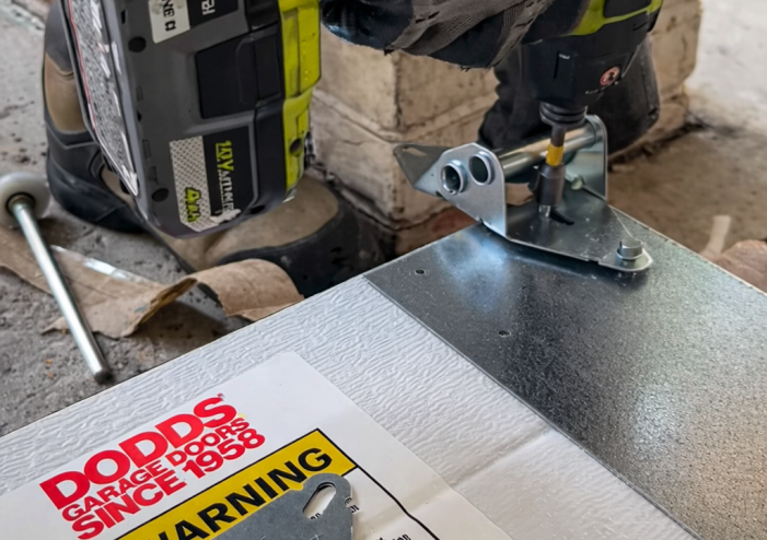 Professional technician performing garage door hinge repair and maintenance in Kitchener.