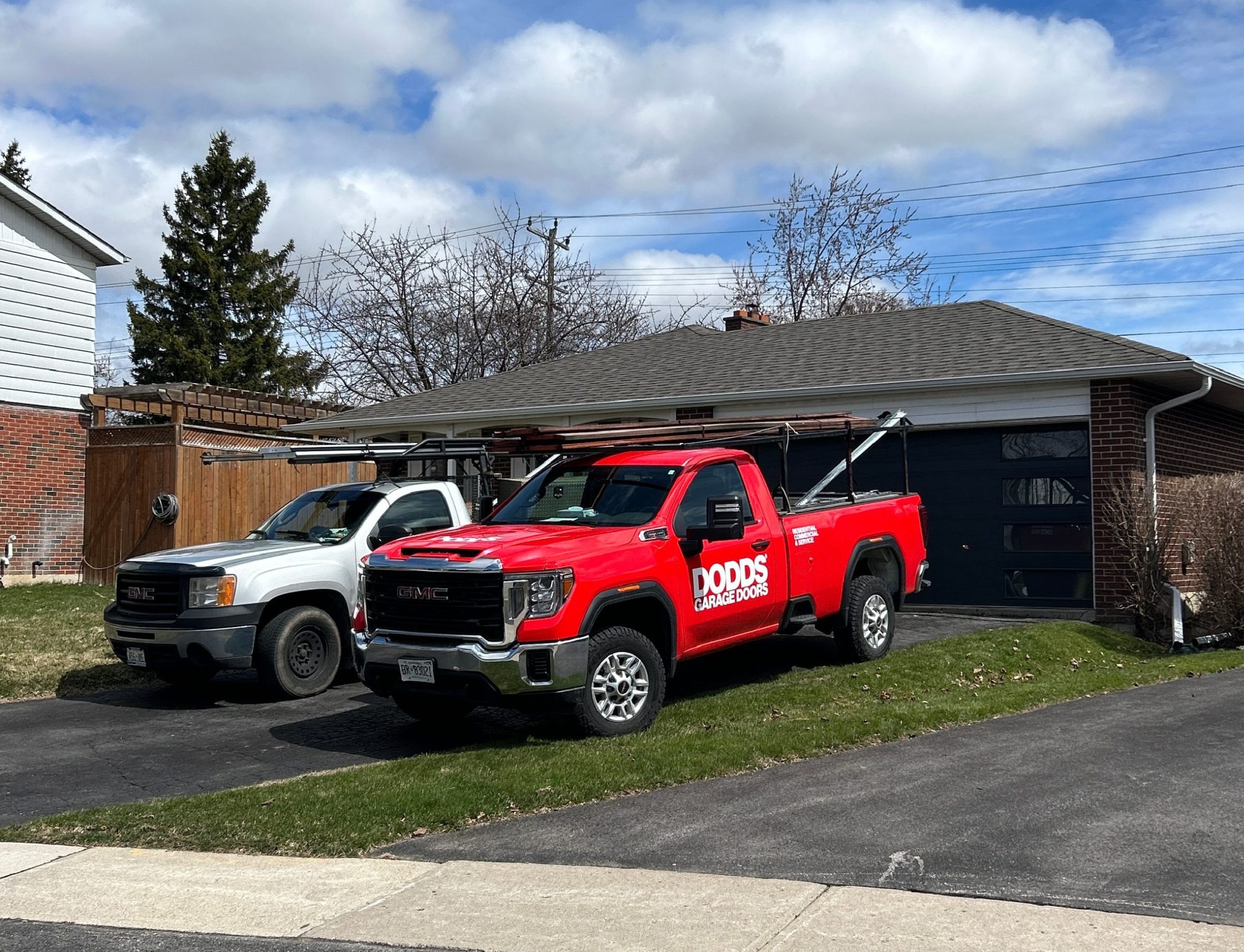 A red Dodds Garage Doors service truck parked in a Scarborough residential driveway for a repair appointment.