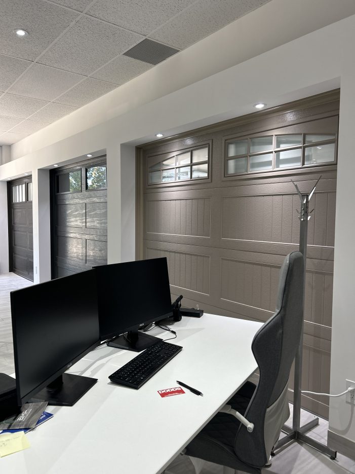 Inside the Dodds Garage Doors showroom featuring various windowed garage door samples and consultation desk.