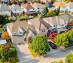 Bird's eye view of detached suburban houses with multi-car garages in Georgetown.