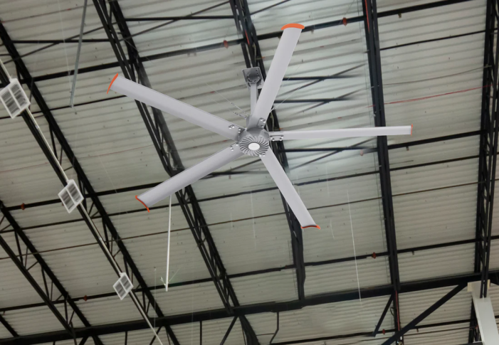 High-volume low-speed (HVLS) industrial ceiling fan installed in a large commercial warehouse for climate control.