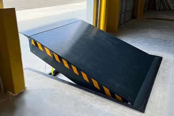 Close-up view of a steel hydraulic dock leveler lip and bumper pads, showing the durable construction for commercial loading docks.