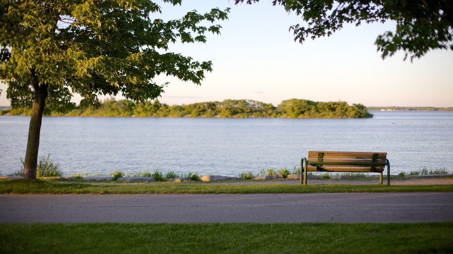 A quiet park bench facing Lake Couchiching at Couchiching Beach Park in Orillia, Ontario.