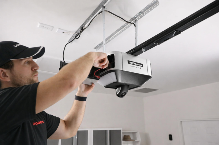 Professional technician installing a LiftMaster smart garage door opener with integrated camera and myQ technology.
