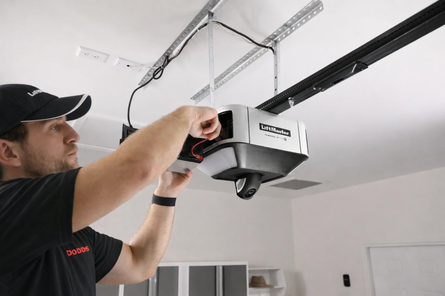 Professional technician installing a LiftMaster smart garage door opener with integrated camera and myQ technology.
