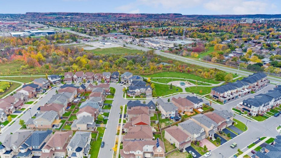 Aerial view of a modern Milton Ontario residential neighborhood with family homes, green space, and colorful autumn trees near the Niagara Escarpment.