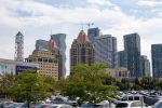 Urban view of Mississauga City Centre buildings, clock tower, and residential high-rises from a local parking lot.