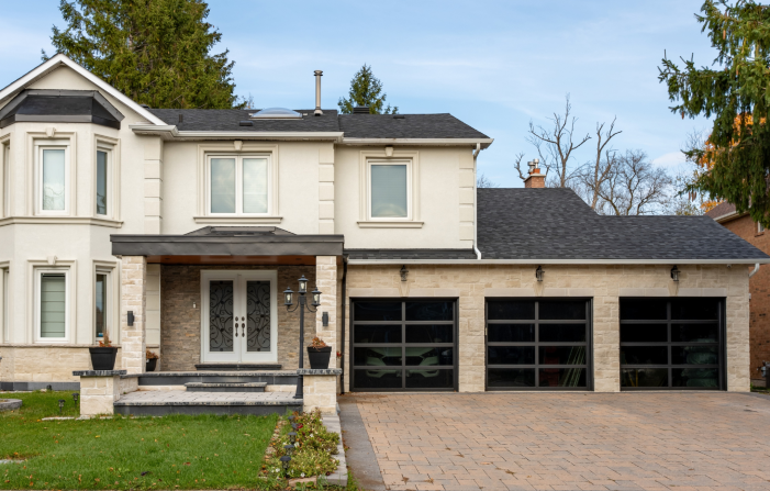 Luxury residential home featuring three modern black-frame glass garage doors installed by Dodds Garage Doors.