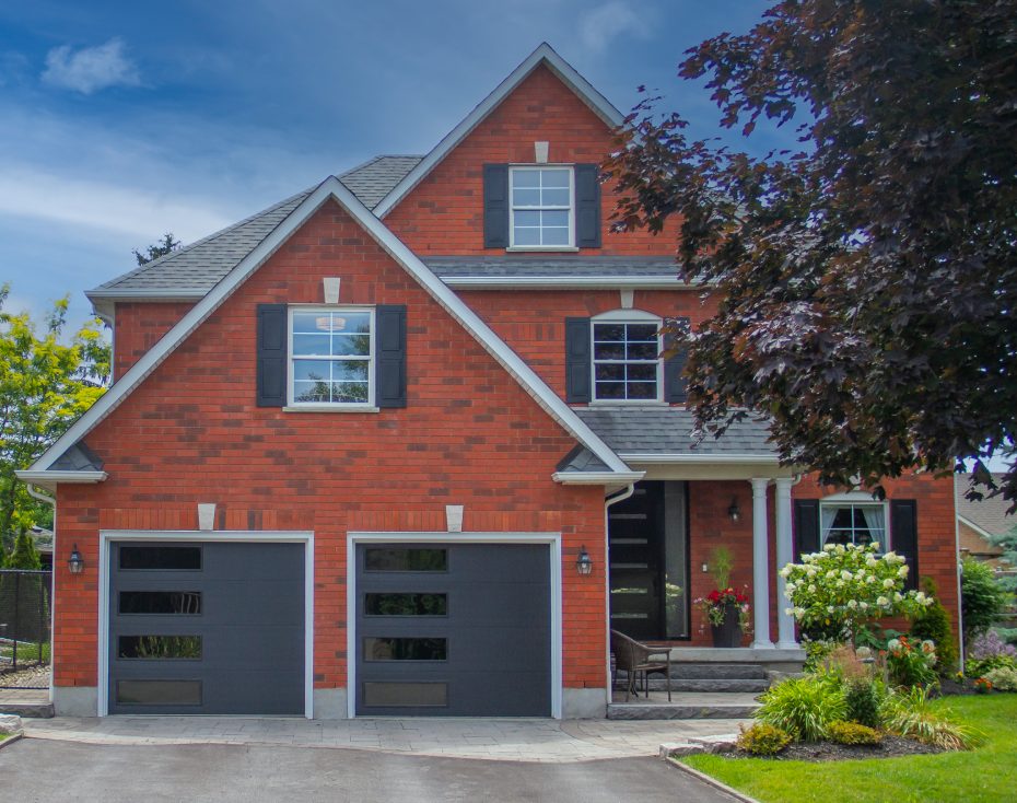 Custom modern garage door installation on a two-story brick home in Vaughan, Richmond Hill, and York Region.