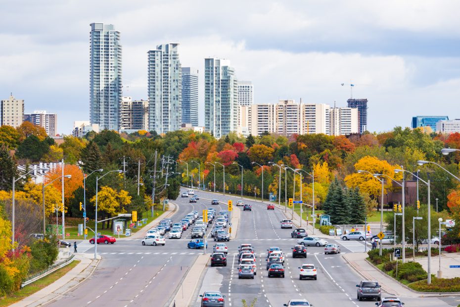 Busy Toronto intersection with autumn trees and modern condominium buildings.