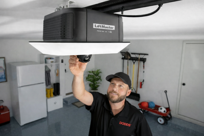 A professional Dodds technician repairing a residential LiftMaster chain-drive opener in an Ontario home to fix common issues like loud noises or unresponsive remotes.