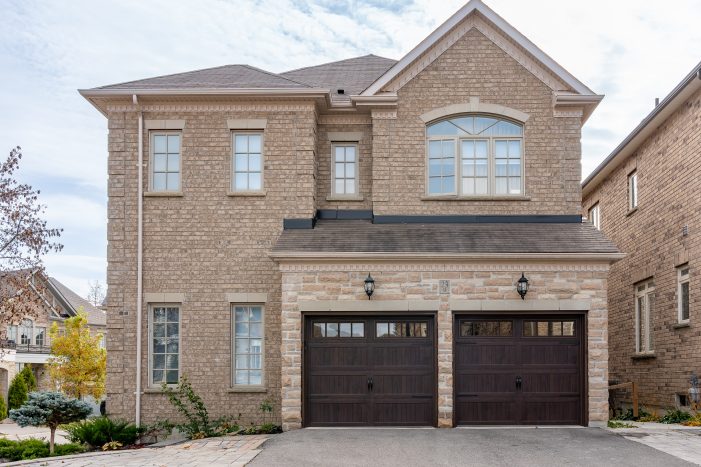 Professional residential garage door installation featuring two espresso brown double-layer steel doors.