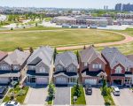 Modern suburban homes in Maple, ON, adjacent to a local school, showing various garage door styles available for installation.