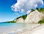 High white cliffs of the Scarborough Bluffs overlooking the sandy beach and Lake Ontario.