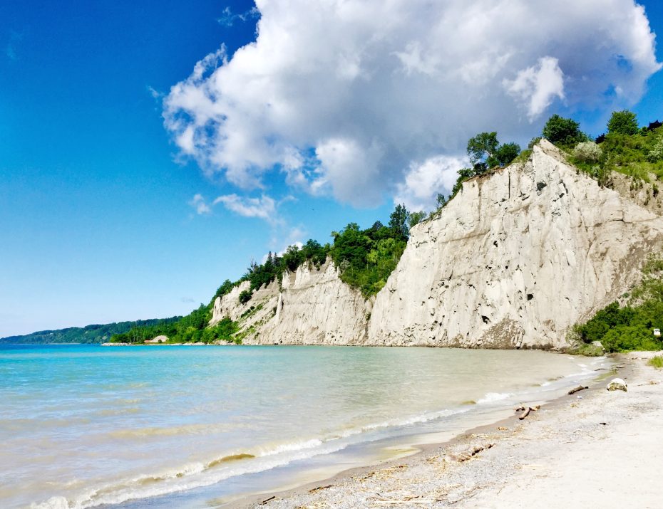 High white cliffs of the Scarborough Bluffs overlooking the sandy beach and Lake Ontario.