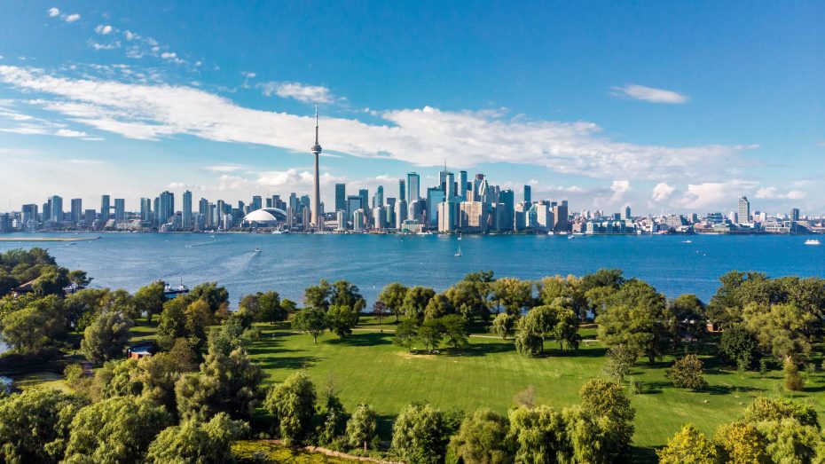 Panoramic view of the Toronto city skyline and CN Tower from across the water.