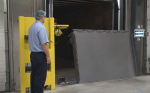 A vertical dock leveler being operated in a climate-controlled facility to maintain environmental integrity and energy efficiency.