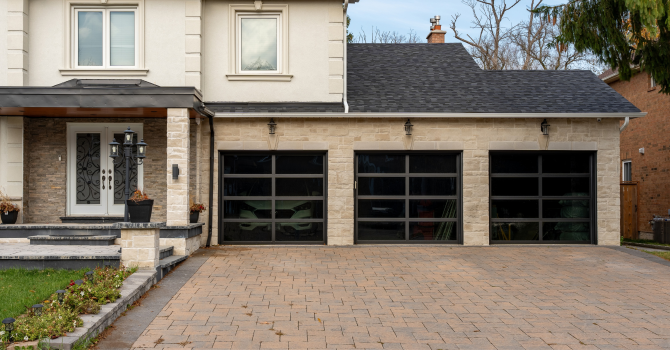 Close-up of residential black aluminum frame garage doors with tinted glass panels.