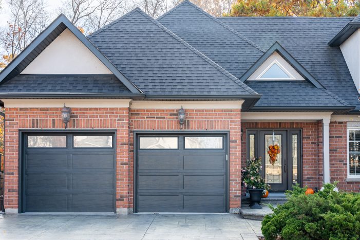 Modern charcoal grey garage doors with windows installed by Dodds Garage Doors in Ontario.