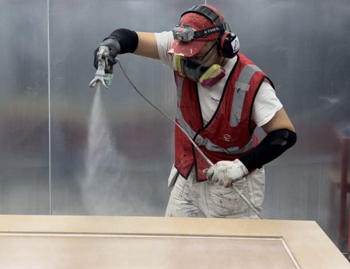 Dodds technician applying a high-quality, durable finish to a residential garage door panel.