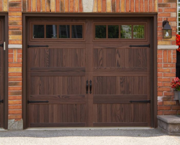 Detailed view of a 3-layer insulated dark oak coach garage door with clear double-glazed Madison window inserts.