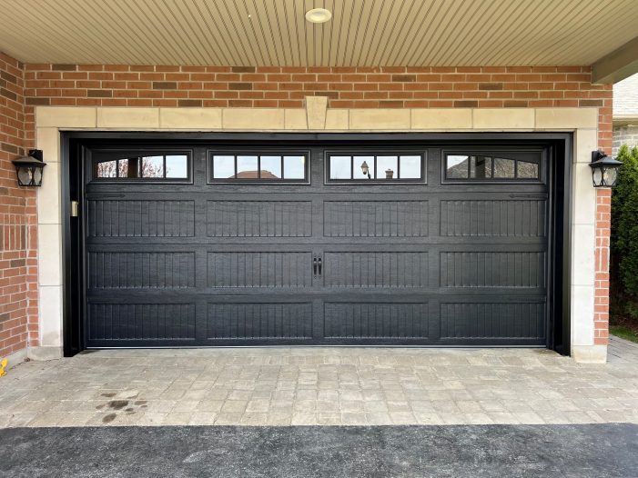 Frontal view of Dodds Canadian Series black recessed long panel coach garage door with Madison arched windows
