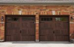 Close-up of Dodds Platinum Series dark oak woodgrain coach garage doors with decorative hardware installed in Whitby.