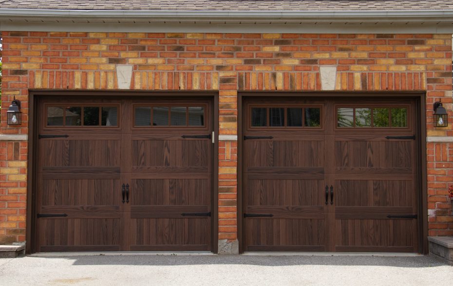 Close-up of Dodds Platinum Series dark oak woodgrain coach garage doors with decorative hardware installed in Whitby.