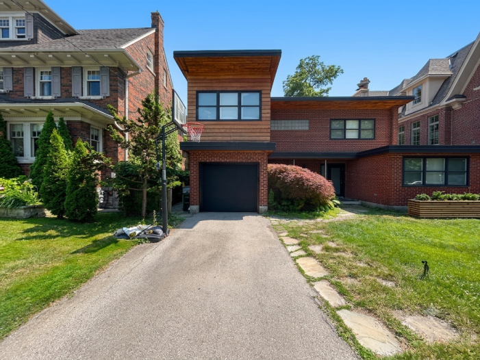 Crisp angle view of a flush modern garage door installed under a wood-accented overhang in Toronto.