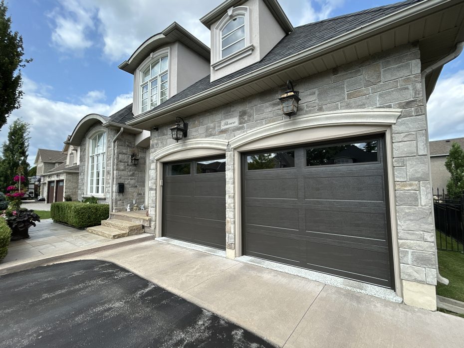 Dodds Cafe recessed long panel garage doors with clear double-glazed windows and dark brown weatherstripping.