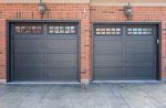 Close-up of a double iron ore long panel recessed garage door installation by Dodds on a brick home.