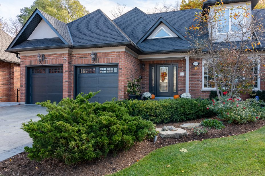Two iron ore long panel recessed garage doors with square top windows installed on a brick home by Dodds.
